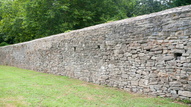istock Grey stone wall in a green park 1411776226