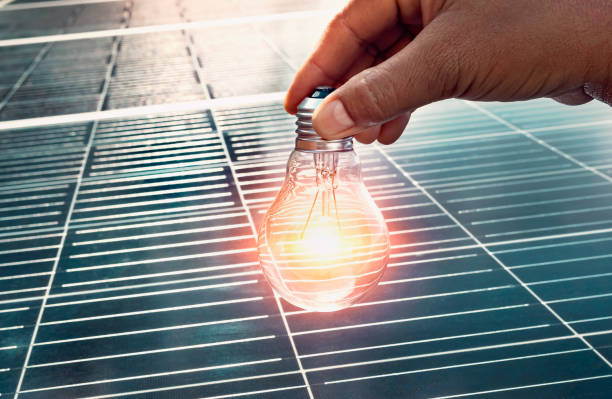 istock hand holding lightbulb on solar panel concept clean energy in nature 1411778641