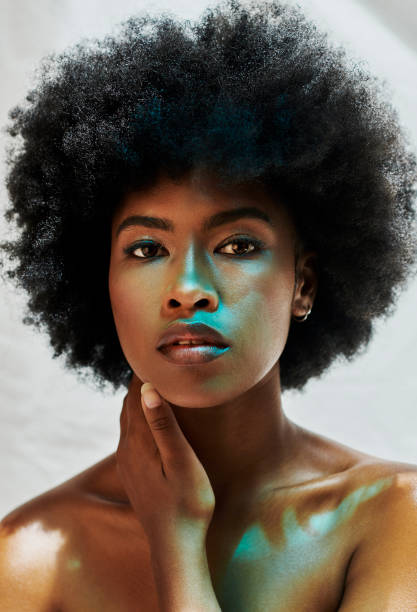 Gorgeous black woman with an afro and perfect and flawless skin. Portrait of a young beautiful and attractive African American female beauty or skincare model with natural curly hair Gorgeous black woman with an afro and perfect and flawless skin. Portrait of a young beautiful and attractive African American female beauty or skincare model with natural curly hair melanin photos stock pictures, royalty-free photos & images