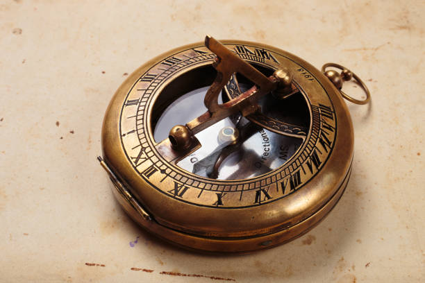 istock Antique compass with sundial on old paper background. 1411779221