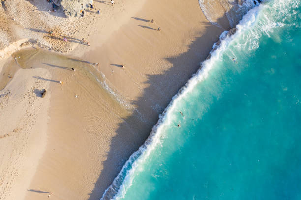 istock Beach scene from above - blue ocean waves hitting a sandy beach. 1411779473