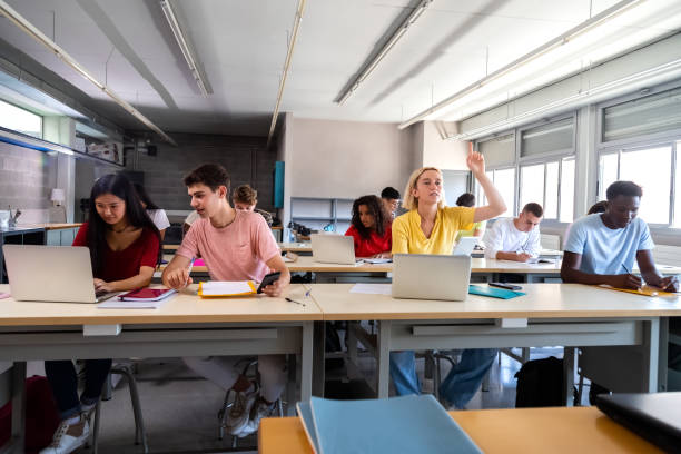 nastoletnia uczennica podnosi rękę, aby zadać pytanie o lekcję w klasie. - teacher computer high school student classroom zdjęcia i obrazy z banku zdjęć