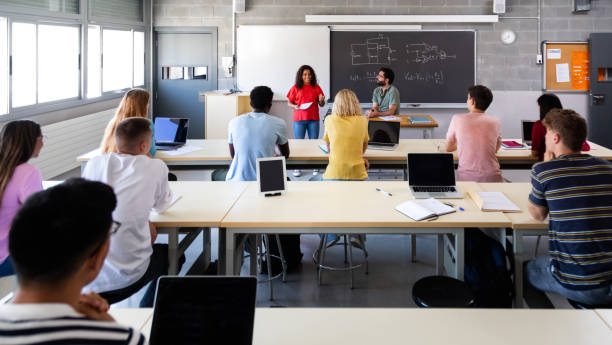 panoramabild von multirassischen schülern, die afroamerikanischen klassenkameraden zuhören, die eine mündliche präsentation halten. - speech talking teenager student stock-fotos und bilder