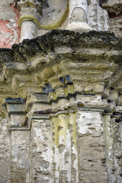 istock Ruins of an ancient synagogue. Texture of old dilapidated masonry. Columns and cornice are made of carved stone. Fragments of old wall paintings. 1411781610