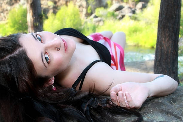 Girl with vivid eyes on rock stock photo