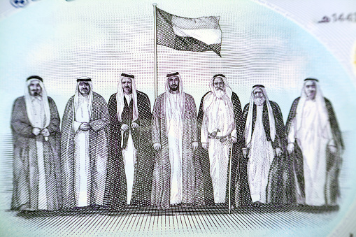The seven founding fathers of UAE United Arab Emirates with flag after signing the union document from the obverse side of the new polymer commemorative 50 fifty Dirhams with Memorial to the martyrs, closeup of Emirates money and selective focus