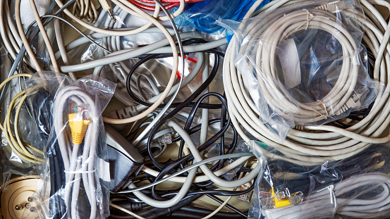 Messy drawer full of wired, cables, thorns, bags