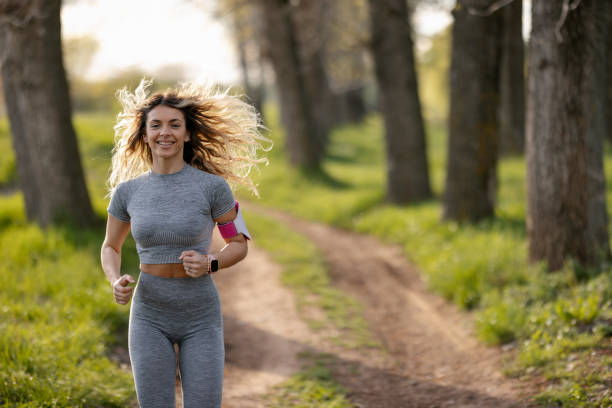 istock Smiling young woman jogging in nature 1411785162