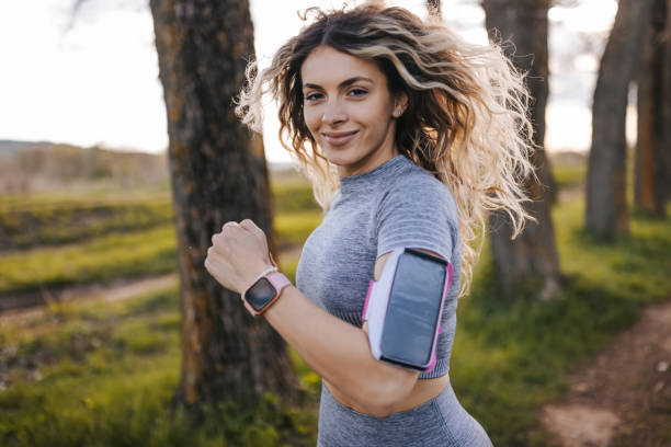 istock Smiling young woman jogging in nature 1411785374