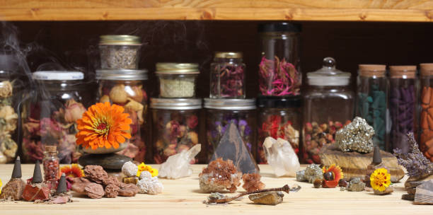 altar de meditación con cristales de roca y flores. frascos de hierbas en el fondo - aragonita fotografías e imágenes de stock