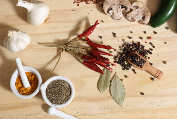 Herbs and Spices on Rustic Table With Jars of Red and Brown Rice in Background Shallow DOF