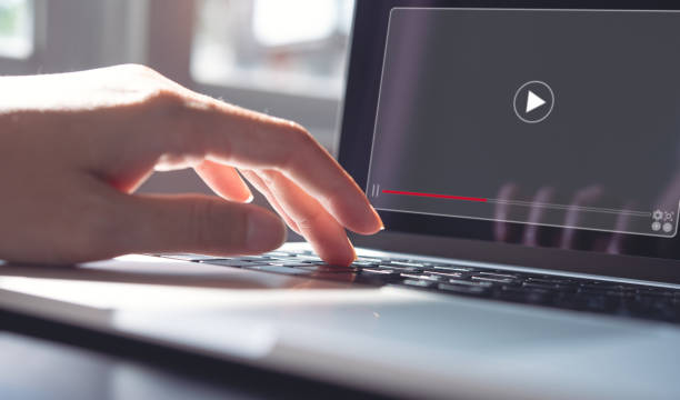 istock Woman working on laptop computer, and watching video player 1411786412