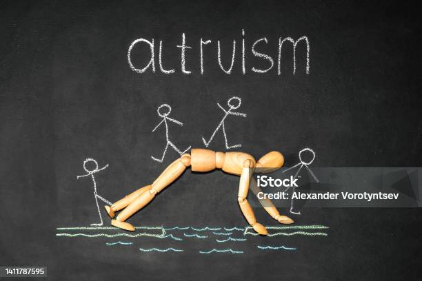 Wooden Man Next To The Inscription Altruism On A Chalk Board Stock Photo - Download Image Now