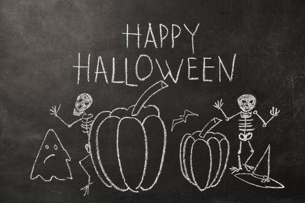 Skeletons, pumpkins and a ghost bat painted on a chalk board. Halloween drawing on chalkboard background. stock photo