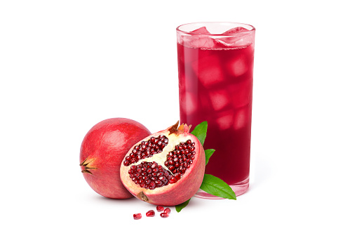Glass of pomegranate juice with fresh fruit isolated on white background.