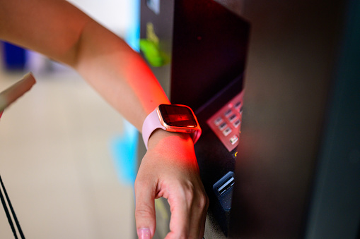 Woman using smart watch to pay at subway station