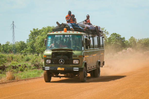 Crowded Green Public Bus with the Bags on the Dusty Road in the heart of Ghana stock photo