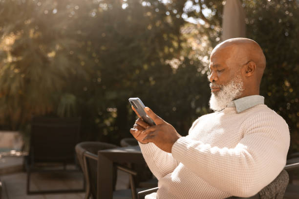 istock Senior man reading on smartphone outdoors 1411793197