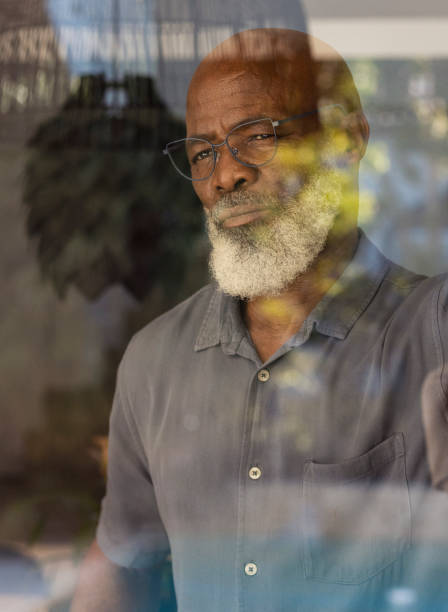 istock Headshot of senior man looking out through his window 1411794994