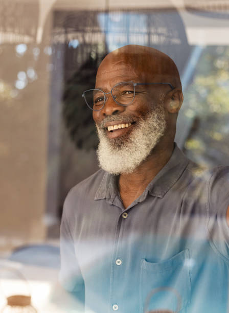 istock Handsome senior man looking out through his window 1411796220