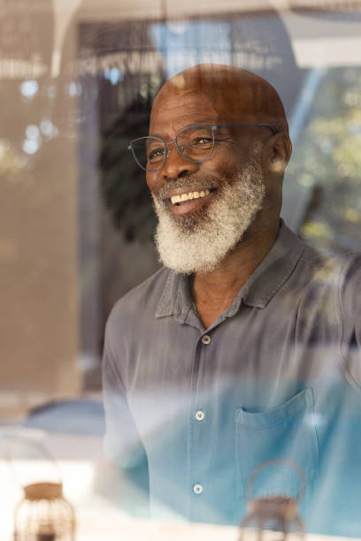 istock Handsome senior man looking out through his window 1411796222