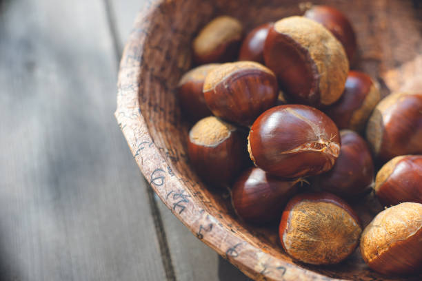 Autumn taste: Chestnut picking Chestnuts in a heap in a bowl stock photo
