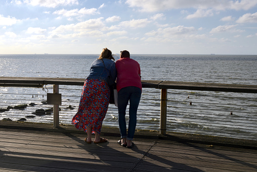 Blankenberge, West-Flanders Belgium - July 10, 2022: caucasian tourist love couple admiring the sea from a Belgian pier