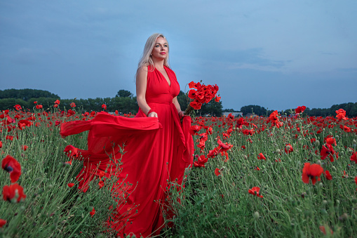 Blond woman in the red dress at the beach in Cyprus.