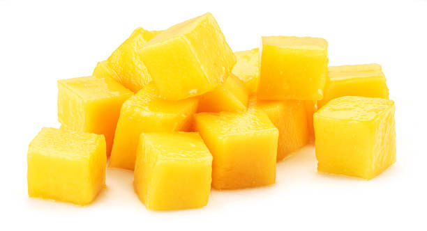 istock Juicy mango cubes isolated on white background. 1411811284