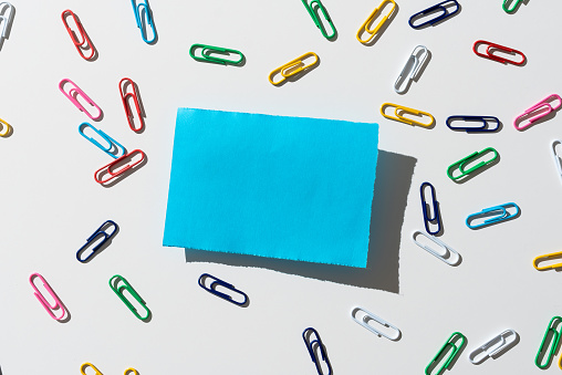 Piece Of Paper With Important Message Surrounded By Colorful Paperclips.