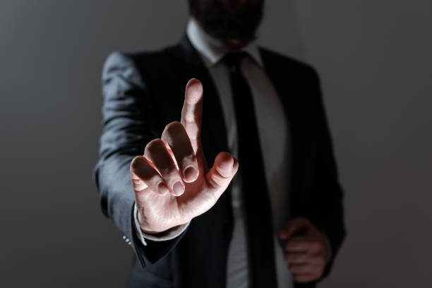 istock Businessman Pointing With One Finger On Important Messages. Executive In Suit Presenting Crutial Informations. Gentleman Showing Critical Announcement. 1411811512