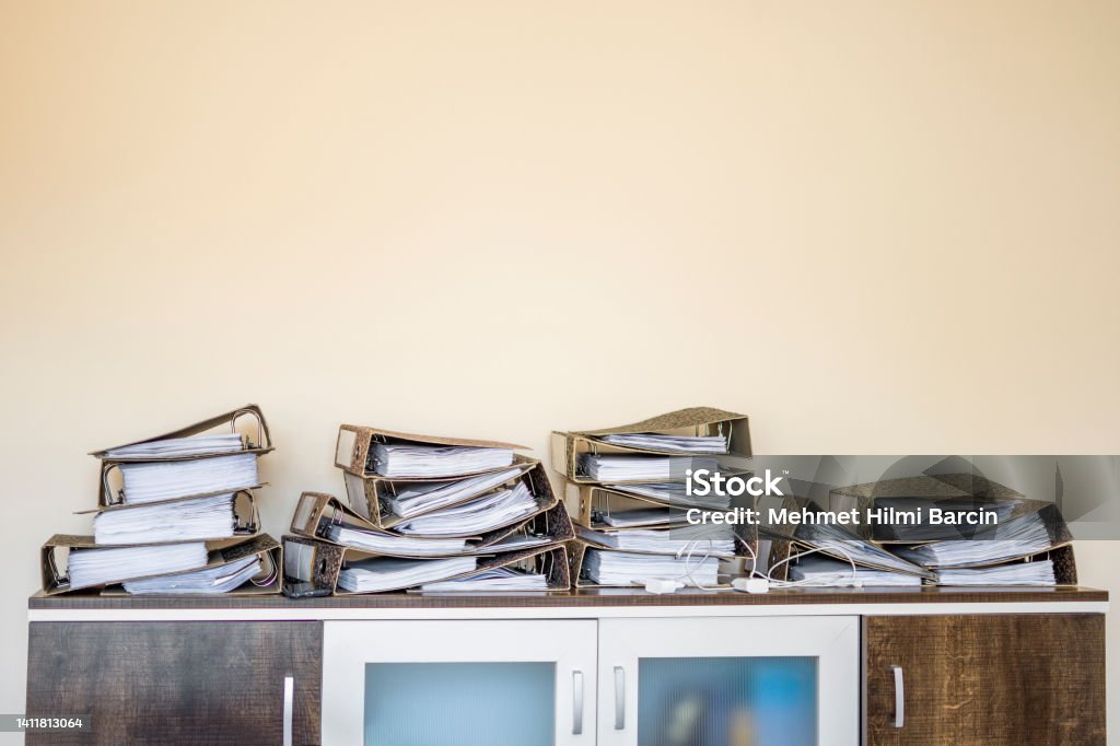 Archive with neglected, old files Messy piles of home office paperwork in folders Ring Binder Stock Photo