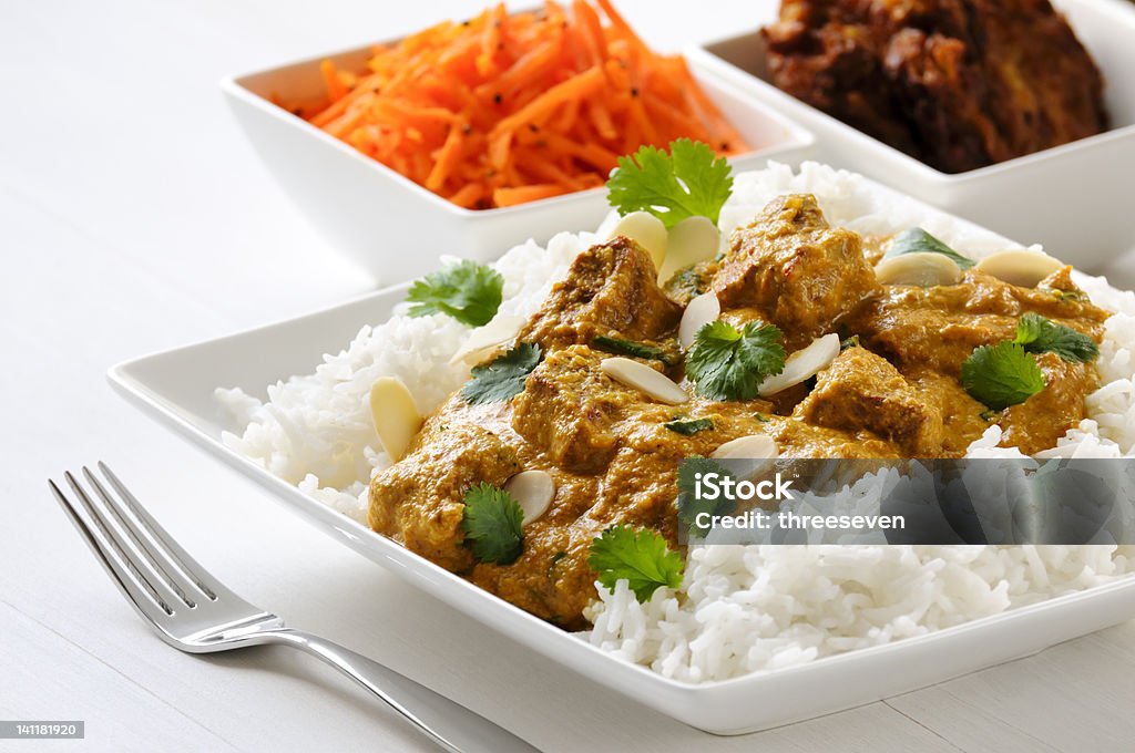 Lamb curry with rice Curry meal - lamb pasanda with rice, bhaji and carrot salad behind. Basmati Rice Stock Photo