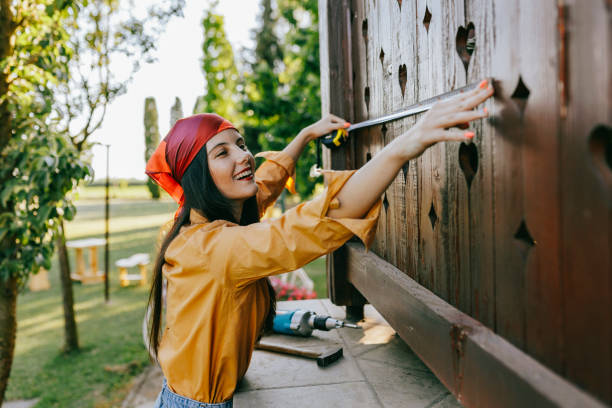 istock Young female interior designer using a measuring tape at home before proceeding with the DIY home improvement 1411821447