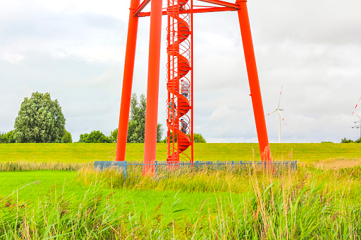 Industrial area cranes red tower lighthouse dyke seascape panorama Germany.