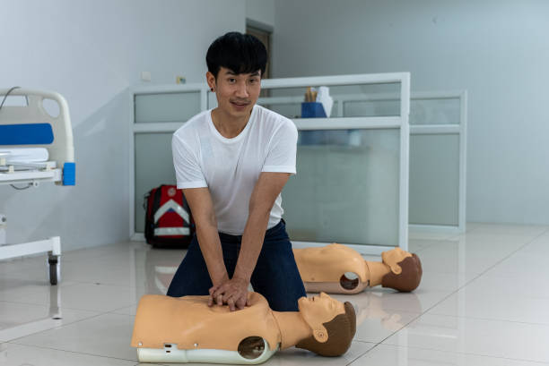 entrenamiento de primeros auxilios, pose de bombeo cardíaco con un maniquí. - cpr first aid paramedic rescue fotografías e imágenes de stock