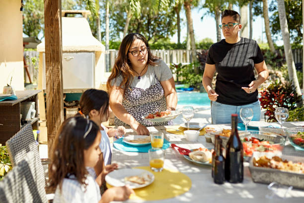 familia de padres lesbianas comiendo comida de fin de semana al aire libre - florida house patio real estate fotografías e imágenes de stock