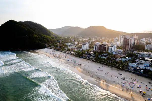 Aerial image of Tombo beach, located in the city of Guarujá. Waves, nature, mountains and bathers.