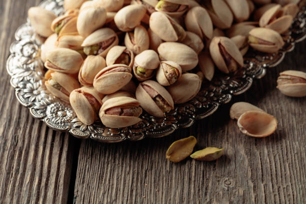 istock Salted pistachios on an old wooden table. 1411828660