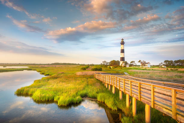 Sunrise Bodie Island Lighthouse OBX Outer Banks NC Part of the beautiful Cape Hatteras National Seashore, the Bodie Island Lighthouse is an Iconic Lighthouse of Nags Head Outer Banks North Carolina. This incredible stretch of coastal barrier islands along the east coast of NC is known for its amazing beaches and abundant wildlife. outer banks north carolina stock pictures, royalty-free photos & images