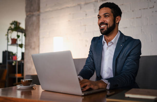 istock Happy young businessman having coffee and doing his work in cafe. 1411830598