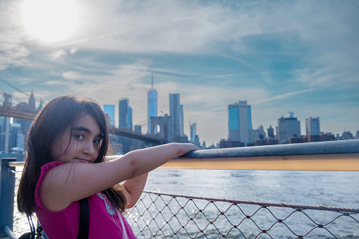 A 7 years old girl, looking Manhattan skyline from Brooklyn Bridge Park