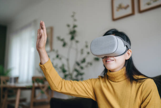 istock Asian female using VR Glasses at home 1411831472