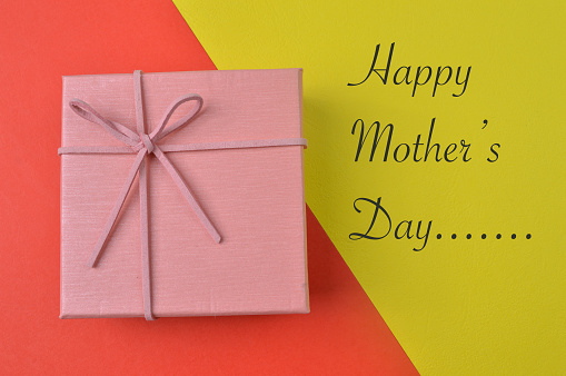 Gift box on red and yellow background with phrase HAPPY MOTHER'S DAY