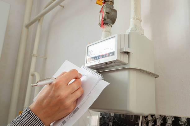 Woman's hand writing down the consumption reading of natural gas at home. stock photo