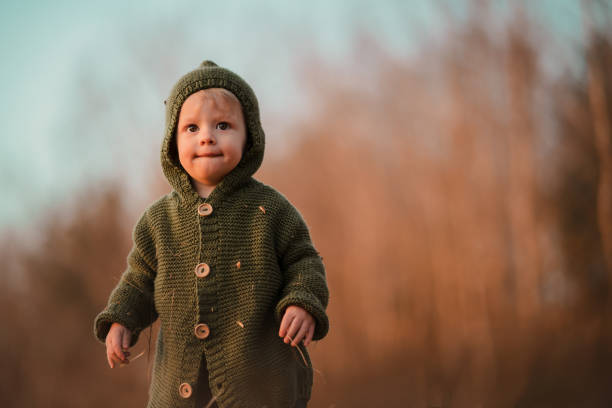 istock Little curious boy on walk in nature, looking at camera. 1411837404