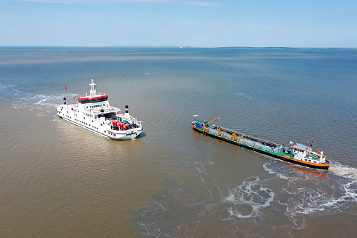 Aerial from the ferry to Ameland and a freighter on the Wadden Sea in the Netherlands