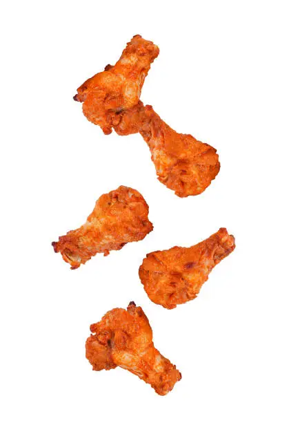 Photo of Barbecue chicken falling in the air isolated on white