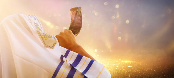 ロシュ・ハシャナ(新年)のショファール(角)を吹くユダヤ人男性。宗教的シンボル - talit ストックフォトと画像