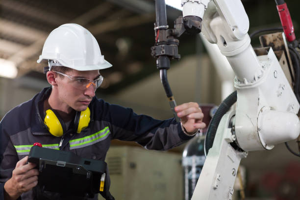 istock Male engineer working at automatic robotic machine factory. Engineer worker maintenance automatic robotic arm machine system welding in the factory 1411841526